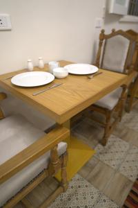 ein Holztisch mit zwei weißen Tellern darauf in der Unterkunft Central Cairo Hotel in Kairo