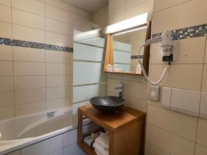 La salle de bains est pourvue d'un lavabo et d'une baignoire. dans l'établissement Logis Hôtel de la Tête Noire, à Autun