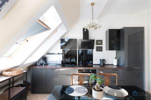 eine Küche im Dachgeschoss mit einem Tisch und einem Esszimmer in der Unterkunft Aviator Superior by 3City Rentals in Sopot