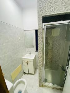 a bathroom with a shower and a toilet and a sink at Come Inn Sesimbra in Quinta do Conde