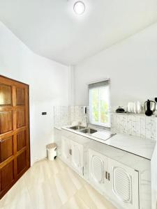 una cucina bianca con lavandino e finestra di Lay Back Villa C4 Kitchen & High Speed Internet a Ban Nong Thale