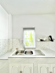 a white kitchen with a sink and a window at Lay Back Villa C4 Kitchen & High Speed Internet in Ban Nong Thale
