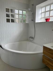 un bagno bianco con vasca e doccia di GITE INDEPENDANT en duplex proche mer COTE DE GRANIT ROSE a Pleubian