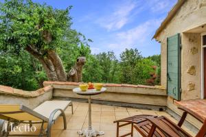 a patio with a table and chairs and a dog statue at Mas du Rocher I Electio in Puget +34 photos