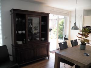 a dining room with a table and a hutch at Garden@Domburg in Domburg +7 photos