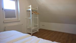 1 dormitorio con estantería blanca junto a la cama en Garden@Domburg en Domburg