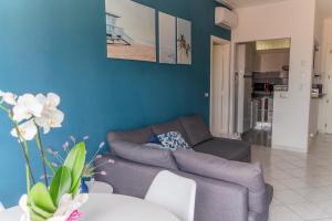 sala de estar con sofá y pared azul en Ad un passo dal molo con 2 biciclette incluse, en Viareggio