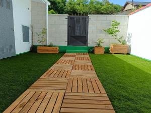 un jardin avec une passerelle en bois sur la pelouse dans l'établissement VUT Corea324, à Caboalles de Abajo