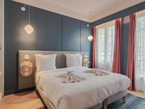 a bedroom with a large bed with blue walls at Aparthotel AMMI Nice Lafayette in Nice