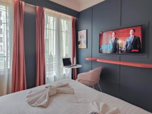 a bedroom with a bed and a tv on the wall at Aparthotel AMMI Nice Lafayette in Nice