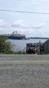 a large ship sitting in the water with a boat at SeaWatch Bed & Breakfast in Halifax