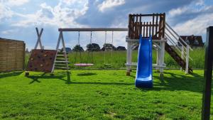 a playground with a slide and a swing at To Je To apartamenty in Maniowy