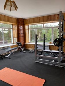 a gym with several treadmills and machines in a room at Opushka in Vorobʼyëvka