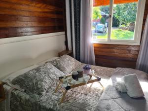 Un dormitorio con una cama y una bandeja. en Chalé Hortênsia - Banheira de Hidromassagem, en Gramado