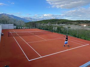 two people playing tennis on a tennis court at #SKGH Arbitrage Hyperluxe Villa -near Pozar Baths & Kaimaktsalan mountain 