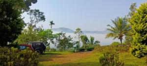 a jeep parked on a dirt road in a field at Verdant Vagamon Cottage in Vagamon