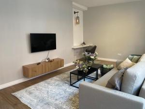 a living room with a couch and a tv on a wall at Ferienwohnung Marzipan - im Herzen der Altstadt, historisches Gebäude mit modernem Ambiente, W-LAN in Lübeck