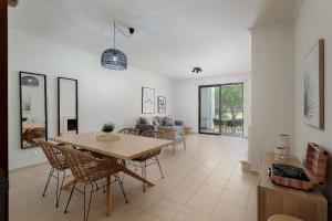 a living room with a wooden table and chairs at Dream 2BDR Apartment W/Pool by LovelyStay in Alvor