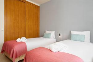 two beds in a hotel room with towels on them at Dream 2BDR Apartment W/Pool by LovelyStay in Alvor