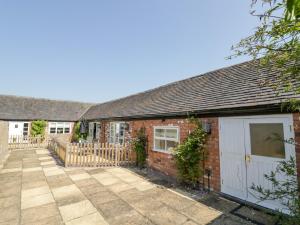 a brick house with a white garage and a fence at The Nest in Nuneaton