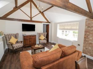 a living room with a couch and a tv at The Nest in Nuneaton