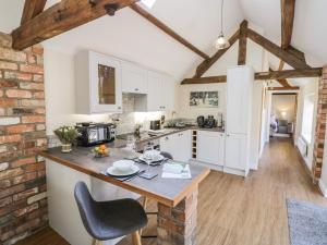 a kitchen with white cabinets and a table with a chair at The Dairy in Nuneaton