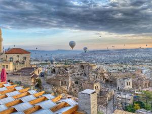 a view of the city with hot air balloons at Takaev Cave House in Uçhisar
