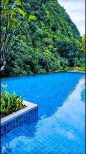 a blue swimming pool with a mountain in the background at Studio suite nearby Lost World of Tambun in Tambun