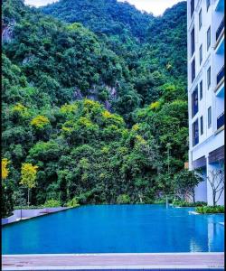 a blue pool of water in front of a mountain at Studio suite nearby Lost World of Tambun in Tambun