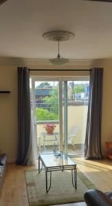 a living room with a glass table in front of a door at Cathedral Court in Ennis