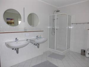 a bathroom with two sinks and a shower at Haus Holldack Wohnung Maria in Goldenstedt