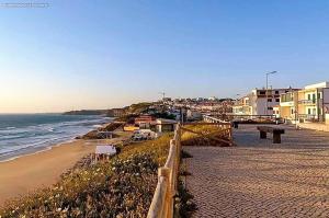 a beach with a fence and the ocean and buildings at The Lookout in Areia Branca