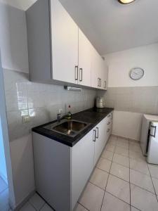 a kitchen with white cabinets and a sink at Apartments Vila Marinela in Poreč