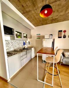 Hermoso Monoambiente en el corazón de Villa Crespo في بوينس آيرس: مطبخ مع طاولة وكراسي في غرفة
