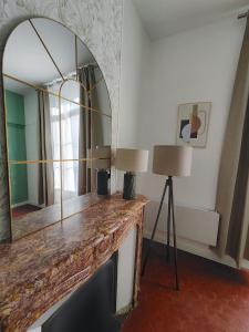 Zimmer mit einem Spiegel und einem Tisch mit zwei Lampen in der Unterkunft Beautiful apartments & Loft in Beziers center in Béziers