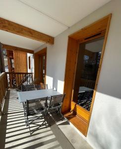 une table et des chaises sur le balcon d'un bâtiment dans l'établissement CosyRefuges - Le Refuge des Marmottes, à Vars