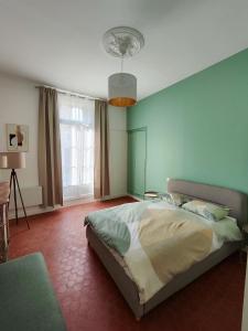 ein Schlafzimmer mit einem Bett und einem großen Fenster in der Unterkunft Beautiful apartments & Loft in Beziers center in Béziers