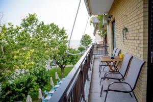 a balcony with chairs and tables on a building at SOSEA in Alexandroupoli