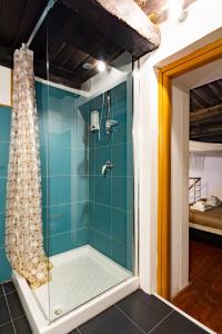 y baño con ducha de azulejos azules. en Napoli Napoli Rooms, en Nápoles