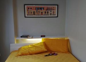 a yellow bed in a room with a picture on the wall at Alba House in Cuneo