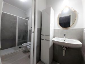 a bathroom with a sink and a toilet and a mirror at Alba House in Cuneo