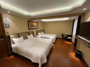 Cette chambre comprend 2 lits et une télévision à écran plat. dans l'établissement R&N SHULLKAS SUITES, à Huancayo