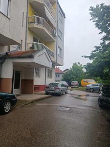 um parque de estacionamento com carros estacionados em frente a um edifício em Doboj Apartman em Doboj
