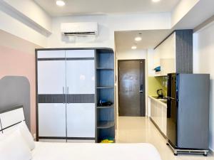 Un dormitorio con nevera y cama y una cocina. en jessica' 1 bed studio condo in canter, en Ho Chi Minh