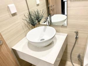 Un baño con un lavabo blanco y un espejo. en jessica' 1 bed studio condo in canter, en Ho Chi Minh