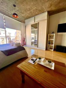 Hermoso Monoambiente en el corazón de Villa Crespo في بوينس آيرس: غرفة نوم مع سرير وطاولة مع طاولة قهوة