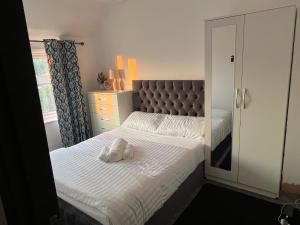 a bedroom with a bed with two white towels on it at Nano Rooms Accommodation in Coventry