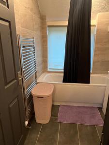 a bathroom with a bath tub and a shower at Nano Rooms Accommodation in Coventry