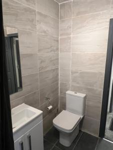 Nano Rooms Accommodation في كوفينتري: حمام به مرحاض أبيض ومغسلة
