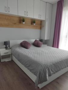 a bedroom with a bed with two pillows on it at Grey Diamond in Târgu-Mureş